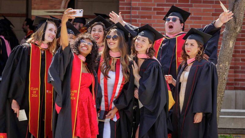 group of graduates pose during the USC Commencement ceremony