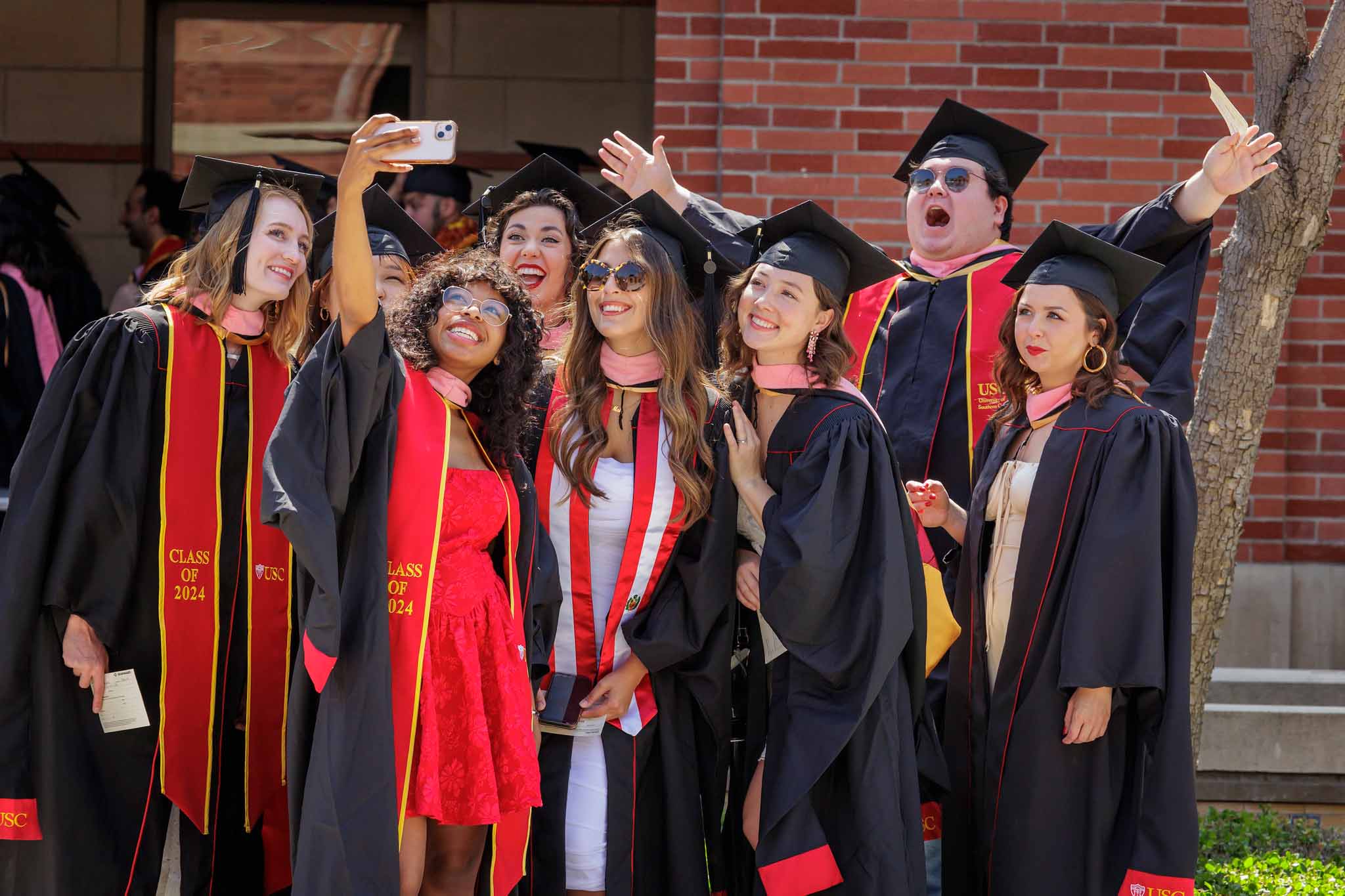 group of graduates pose during the USC Commencement ceremony