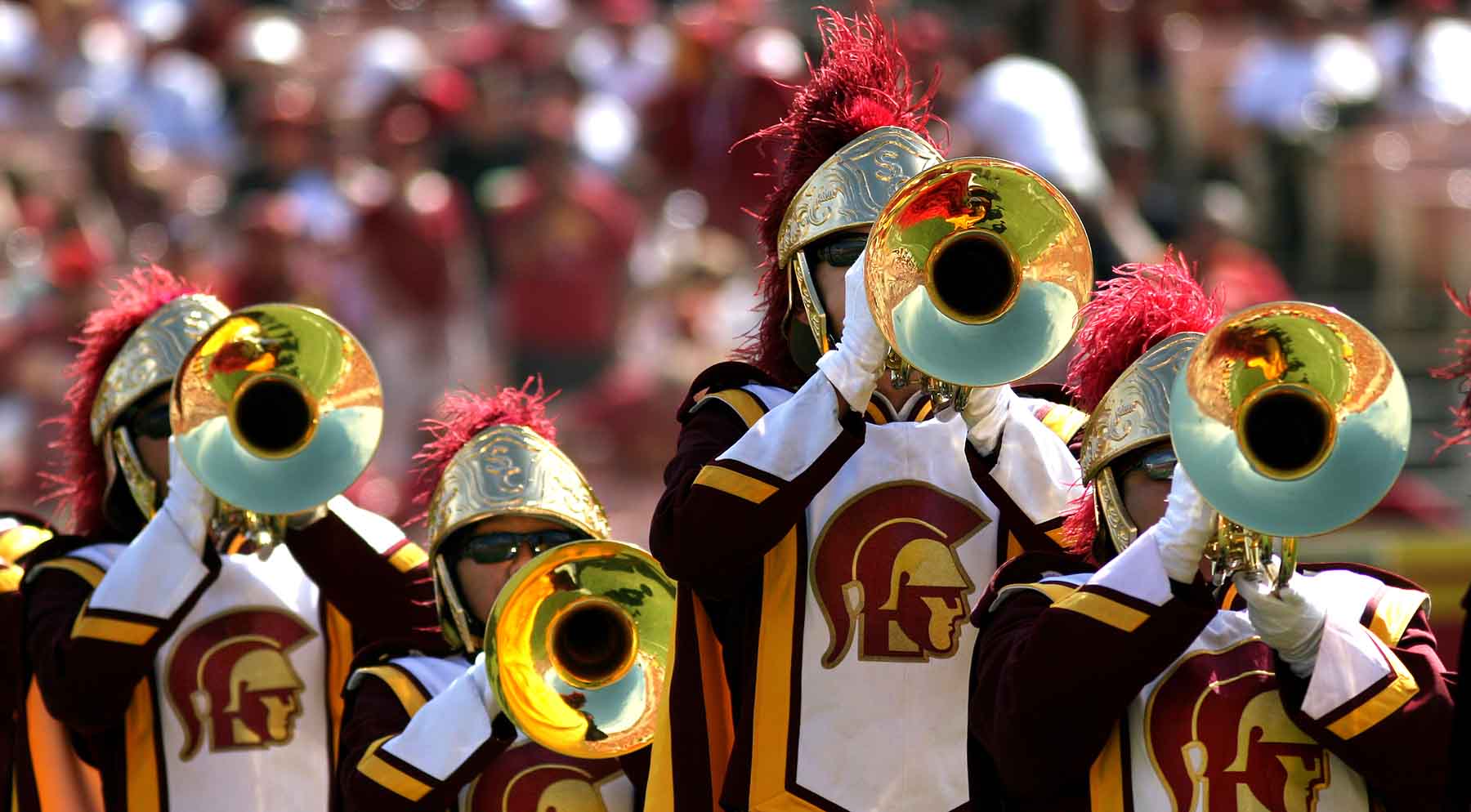 members of Trojan Marching Band play their trumpets during a game